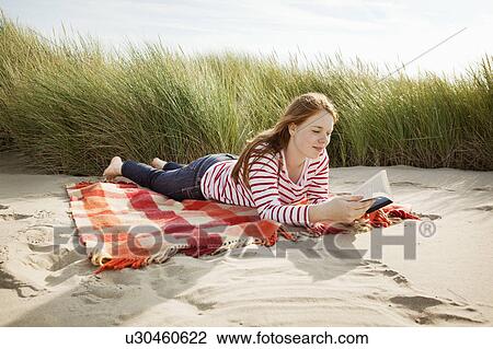 Teenager reading book in sand dunes View Large Photo Image Stock Image - Teenager reading book in sand dunes. Fotosearch
