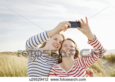 Teenagers taking self-portrait on mobile View Large Photo Image Stock Image - Teenagers taking self-portrait on mobile. Fotosearch