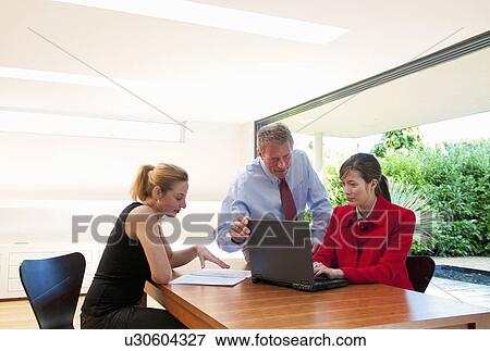 Three business people check data View Large Photo Image Stock Photo - Three business people check data. Fotosearch