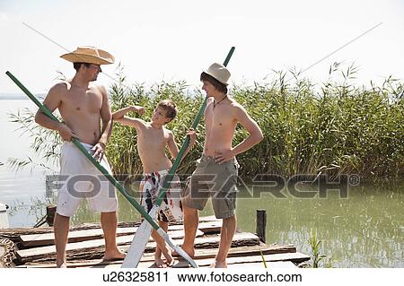 Three friends joke on a jetty View Large Photo Image Stock Image - Three friends joke on a jetty. Fotosearch