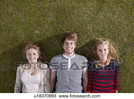 Three friends lying smiling View Large Photo Image Stock Image - Three friends lying smiling. Fotosearch