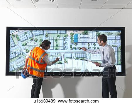 Stock Photo - Town planners look at plans on screen. Fotosearch