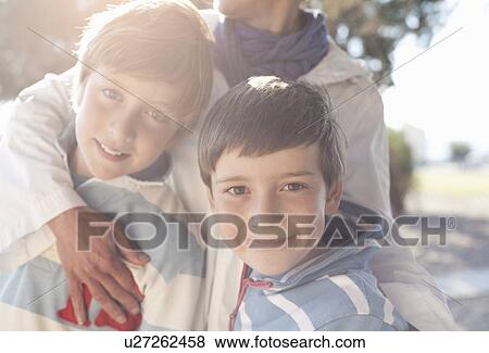 Two boys being hugged by woman View Large Photo Image Stock Photo - Two boys being hugged by woman. Fotosearch