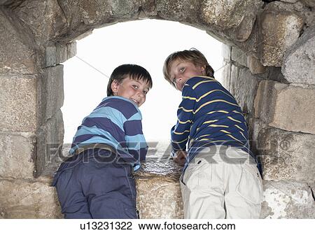Two boys looking at view through window View Large Photo Image Stock Image - Two boys looking at view through window. Fotosearch
