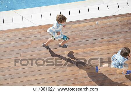 Two boys running, aerial view View Large Photo Image Stock Photo - Two boys running, aerial view. Fotosearch