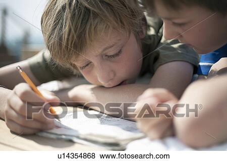 Stock Photo - Two boys writing together. Fotosearch