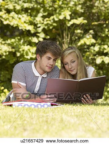 Stock Photo - Two friends reading a book. Fotosearch