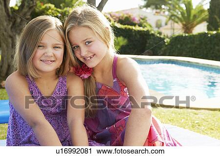 Two girls hugging by pool View Large Photo Image Stock Image - Two girls hugging by pool. Fotosearch