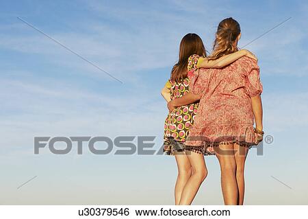 Two girls hugging on the beach View Large Photo Image Stock Photograph - Two girls hugging on the beach. Fotosearch