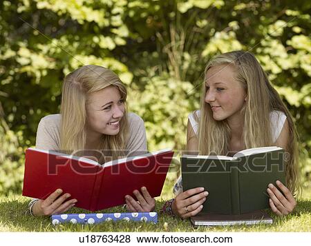 Stock Photo - Two girls reading in the park. Fotosearch