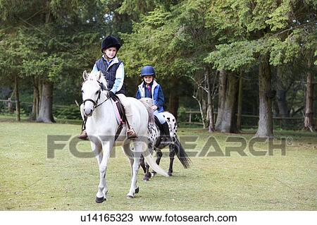 Two girls riding their ponies View Large Photo Image Stock Image - Two girls riding their ponies. Fotosearch