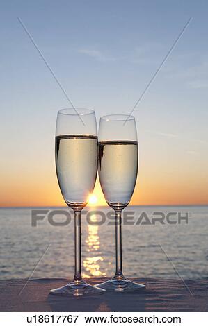 Stock Photo - Two glasses of champagne at sunset. Fotosearch