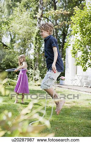 Stock Photo - Two kids enjoying themselves in garden. Fotosearch