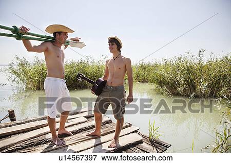 Stock Photo - Two men chatting in the sun lakeside. Fotosearch