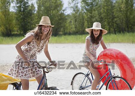 Two pretty women cycling on the beach View Large Photo Image Picture - Two pretty women cycling on the beach. Fotosearch