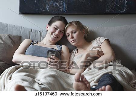Two young woman reading text message View Large Photo Image Stock Image - Two young woman reading text message. Fotosearch
