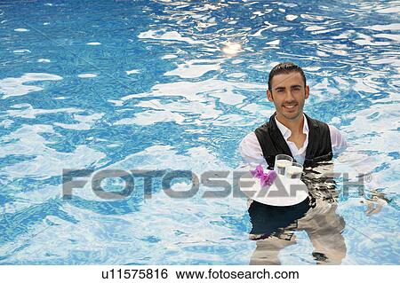 Stock Photograph - Waiter with a trey of drinks in a pool. Fotosearch