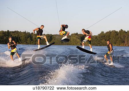 Stock Image - Wakeboarder performing 360 trick. Fotosearch