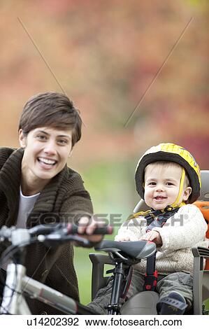 Woman and child cycle together in park View Large Photo Image Stock Image - Woman and child cycle together in park. Fotosearch