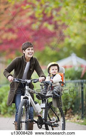 Woman and child cycling in the park View Large Photo Image Stock Photo - Woman and child cycling in the park. Fotosearch