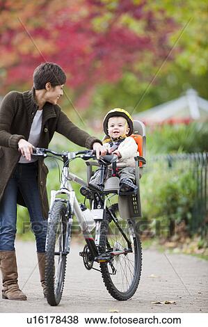 Stock Photo - Woman and child cycling in the park. Fotosearch