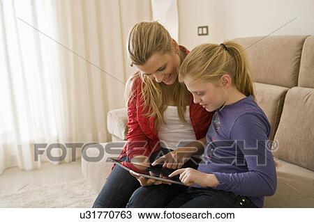 Woman and girl using tablet computer View Large Photo Image Stock Image - Woman and girl using tablet computer. Fotosearch