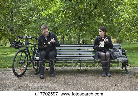 Woman and man eating lunch on park bench View Large Photo Image Stock Photo - Woman and man eating lunch on park bench. Fotosearch