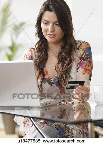 Stock Photography - Woman at home shopping online. Fotosearch