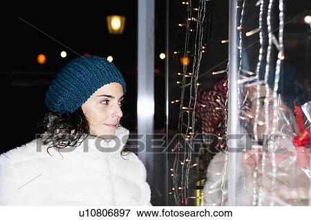 Stock Photo - Woman by night looking at shopwindow. Fotosearch
