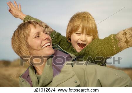 Woman carrying young boy on beach. Fall View Large Photo Image Picture - Woman carrying young boy on beach. Fall. Fotosearch