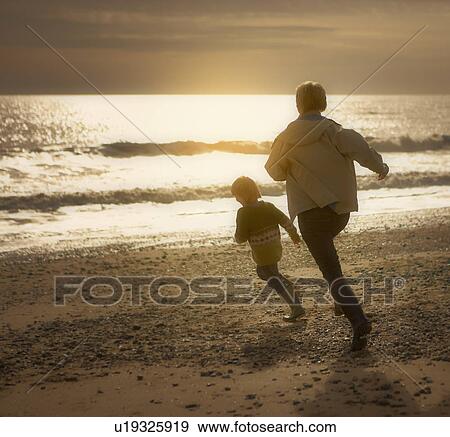 Woman chasing young boy on beach. Autumn View Large Photo Image Stock Photo - Woman chasing young boy on beach. Autumn. Fotosearch