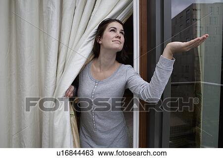 Woman checking for rain View Large Photo Image Stock Image - Woman checking for rain. Fotosearch