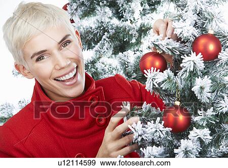 Woman decorating a christmas tree View Large Photo Image Stock Photo - Woman decorating a christmas tree. Fotosearch