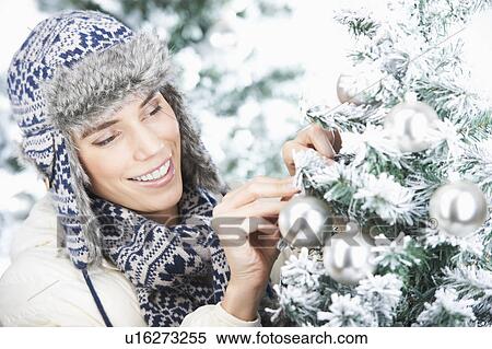 Stock Photography - Woman decorating a christmas tree. Fotosearch