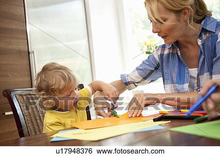 Woman doing handicraft with child View Large Photo Image Stock Photograph - Woman doing handicraft with child. Fotosearch