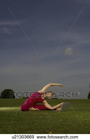 Stock Photo - Woman doing yoga in park. Fotosearch
