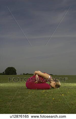 Stock Photography - Woman doing yoga in park. Fotosearch