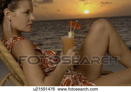 Woman drinking cocktail on beach View Large Photo Image Stock Photograph - Woman drinking cocktail on beach. Fotosearch