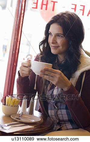 Stock Photo - Woman drinking coffee in cafe. Fotosearch
