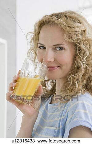 Stock Image - Woman drinking orange juice. Fotosearch