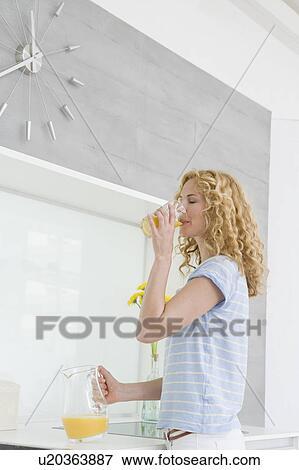 Stock Photo - Woman drinking orange juice. Fotosearch