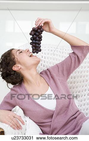 Woman eating grapes View Large Photo Image Stock Image - Woman eating grapes. Fotosearch