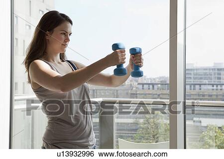 Woman exercising with weights View Large Photo Image Stock Photograph - Woman exercising with weights. Fotosearch