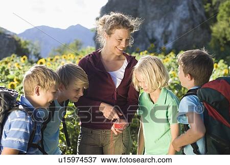 Woman explaining a compass to boys View Large Photo Image Stock Photo - Woman explaining a compass to boys. Fotosearch