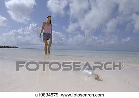 Woman finding postbottle View Large Photo Image Stock Photo - Woman finding postbottle. Fotosearch