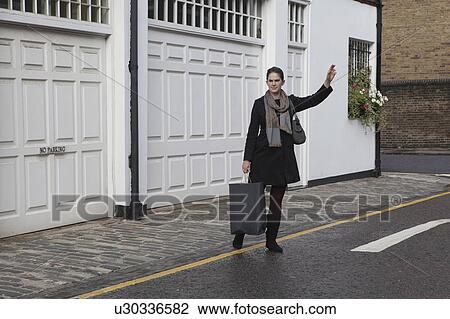 Woman hailing taxi View Large Photo Image Stock Image - Woman hailing taxi. Fotosearch