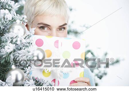 Stock Image - Woman holding a christmas present. Fotosearch