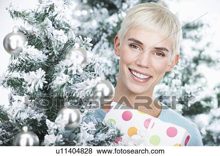 Woman holding a christmas present View Large Photo Image Stock Photo - Woman holding a christmas present. Fotosearch