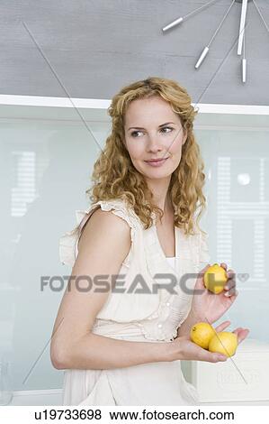 Stock Photo - Woman holding lemons. Fotosearch