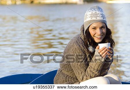 Woman holding mug in row boat View Large Photo Image Stock Photo - Woman holding mug in row boat. Fotosearch